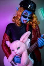celebrity sex doll neon punk elf character holding bass guitar with colorful lighting stage style portrait